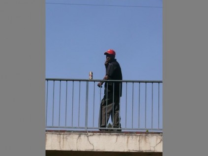 Public Drinking... A man has a beer in the park.