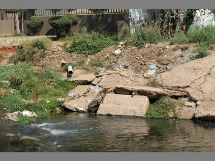 Building rubble comes tumbling down… the Sandspruit River shares its waters with building rubble.