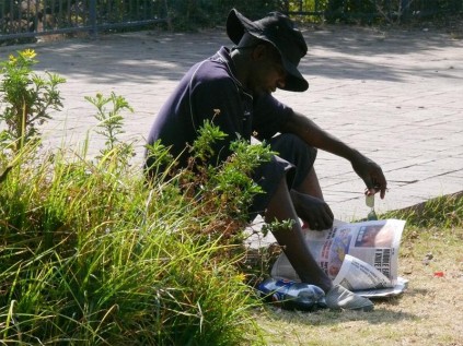 Taking over the park... A vagrant is using the facilities in the park as if it were his own home.