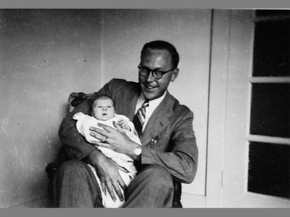 Father... James Pitcher is held by his father John PItcher in the gown in 1947.