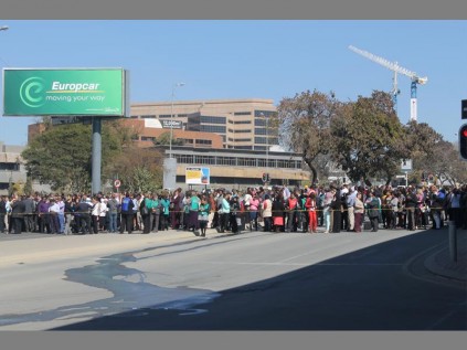 Employees from both buildings stand beyond the cordoned off area while both buildings are searched for explosives