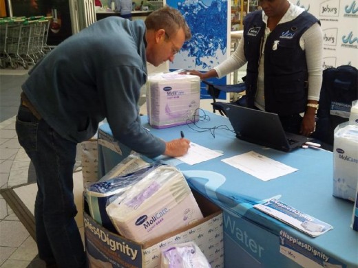 A Joburg Water employee with one of the people who donated nappies.