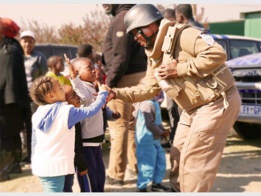 ADT Reaction Officer, Thomas Motshwari, shares a special moment during Mandela Day with a child from Thuthuzela Community Centre.
