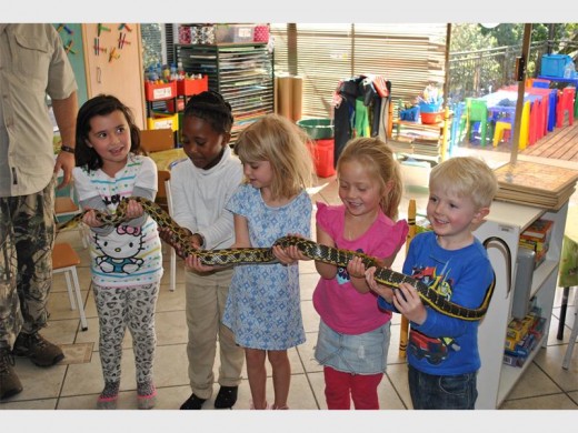 Scarlet Howard, Lethabo Moeti, Sarah Degener, Leah Baker and Jonty Mare hold a snake.