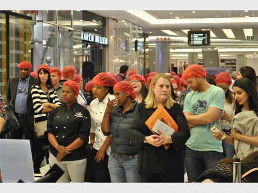 Volunteers line up for the final food-packing shift of the day at Sandton City.