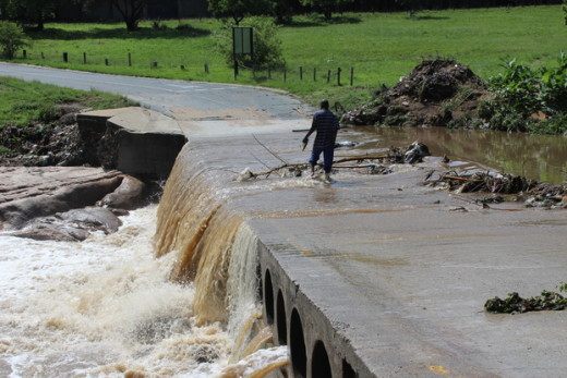A pedestrian dangerously makes his way across a very flooding Belgrave Bridge on 11 November after a week of rainfall and floods.
