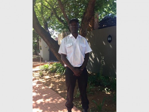 Freddy Ndaba stands outside Parkmore Nursery School where he works as a security guard.